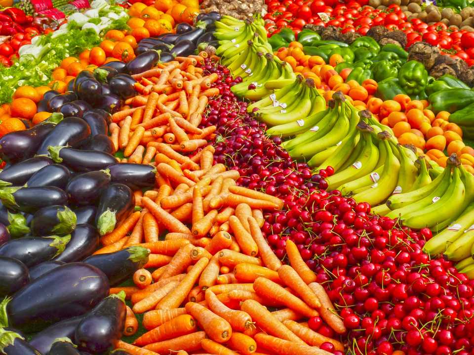 Imagem: https://www.pexels.com/ Imagem com filas de legumes na vertical: berinjelas, cenouras, cerejas, bananas, pessegos, pepinos, tomates..